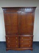 A Georgian style mahogany double door press fitted six drawers beneath with brass drop handles