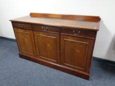 A 20th century mahogany triple door sideboard, fitted three drawers above.