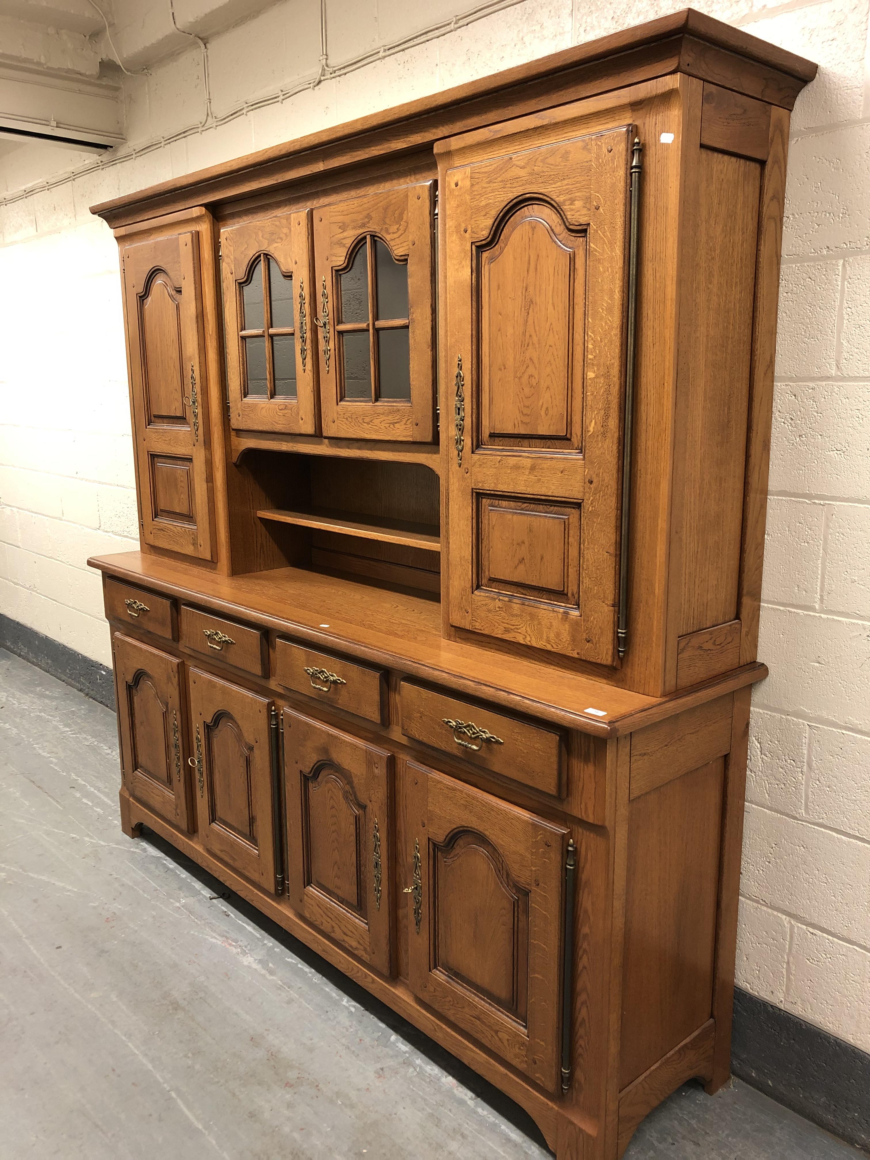 A 20th century oak dresser fitted eight cupboards and four drawers with brass bow handles,