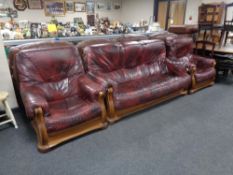 A wooden framed Burgundy leather three piece lounge suite