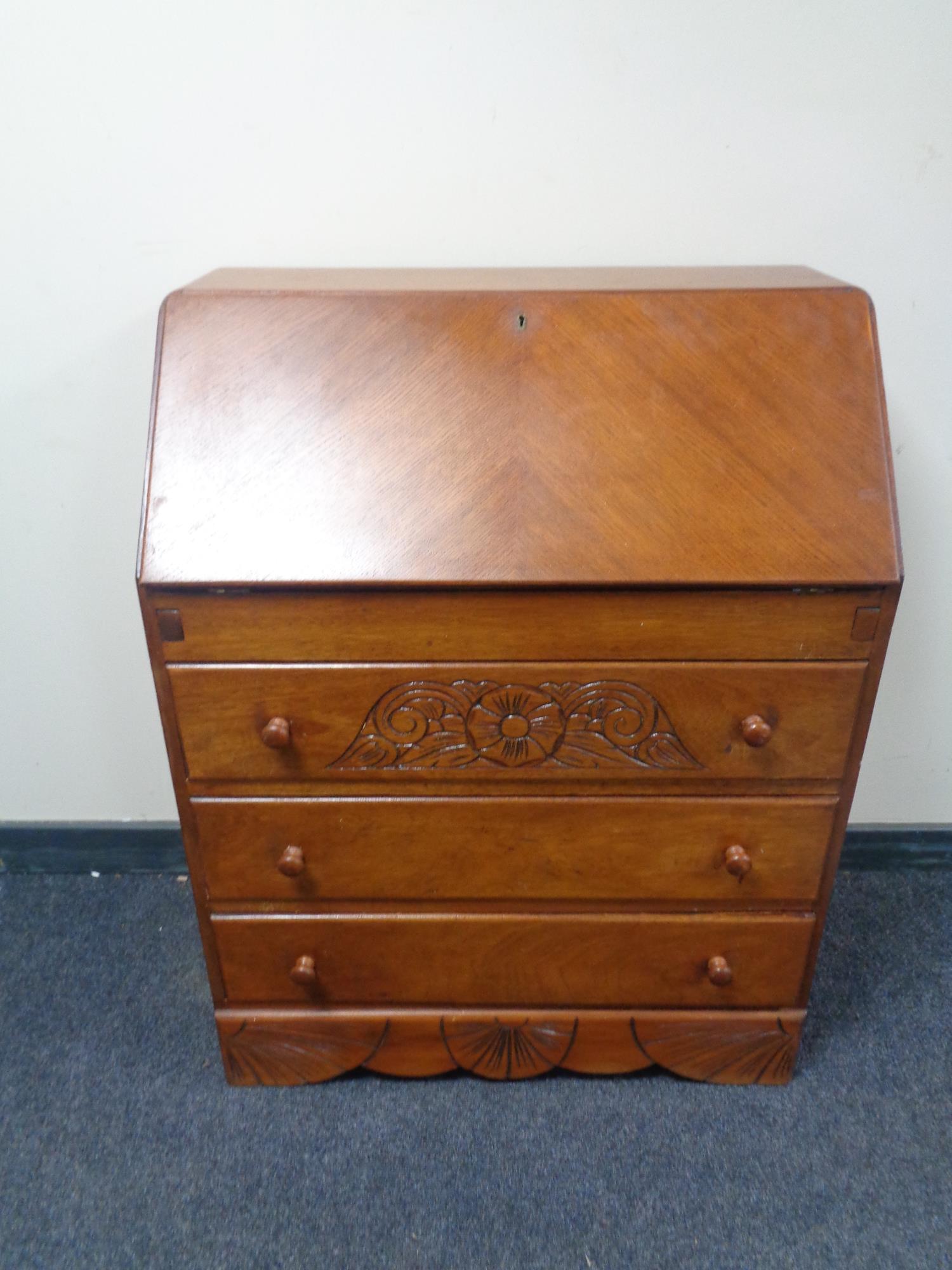 A mid 20th century writing bureau fitted three drawers beneath