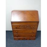 A mid 20th century writing bureau fitted three drawers beneath