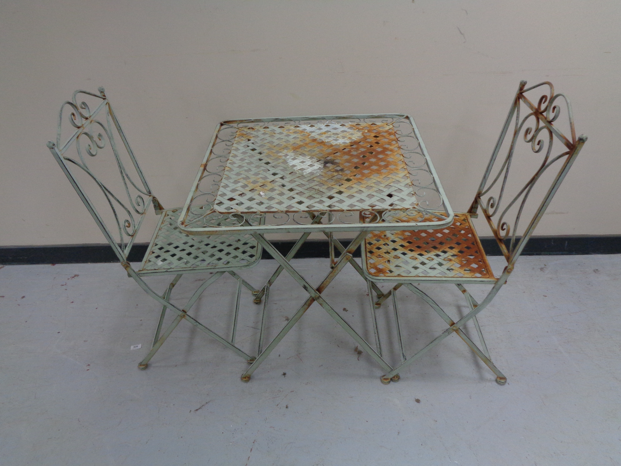 A folding metal patio table and two chairs (green).