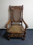 An Edwardian heavily carved armchair with bergere seat and back.