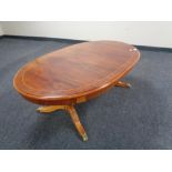 An oval inlaid mahogany coffee table with under stretcher and brass capped feet.