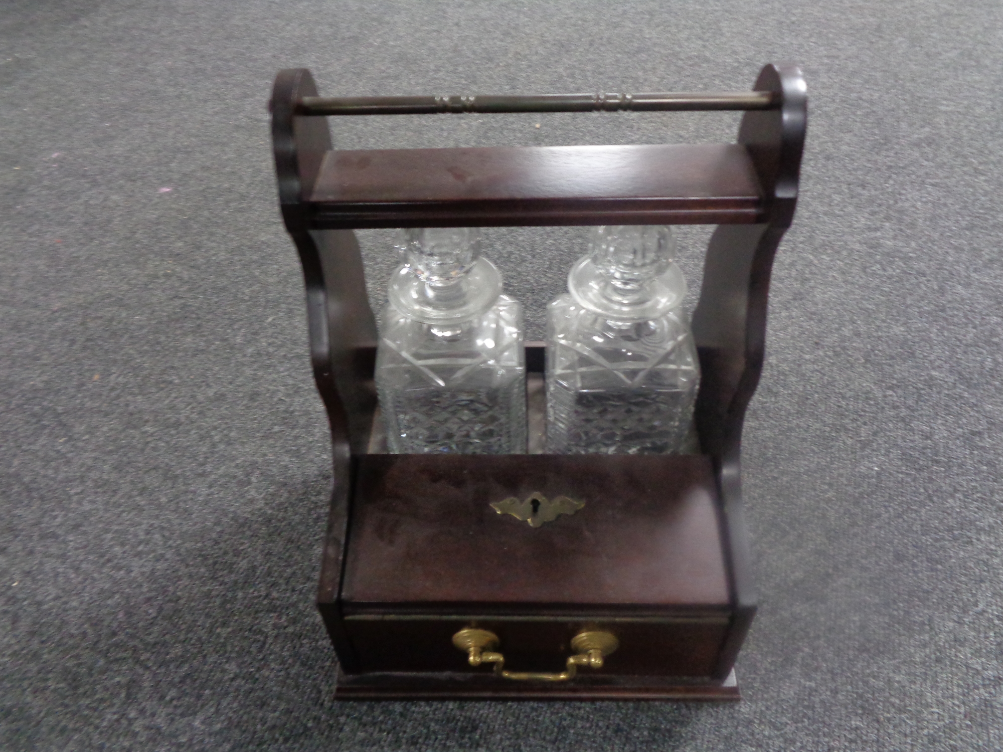 A 20th century Tantalus with two cut glass whiskey decanters and glasses, whiskey decanter label.
