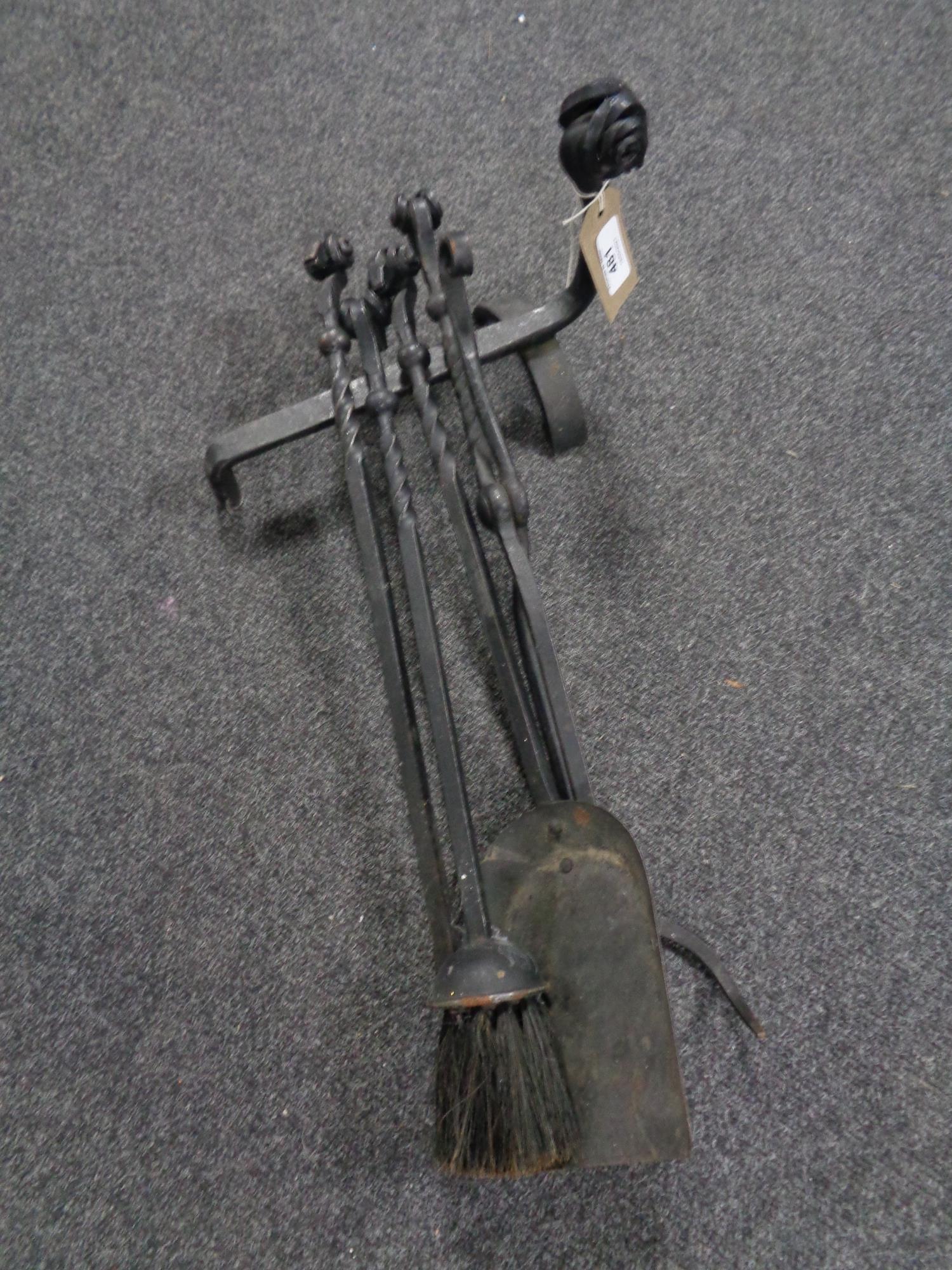 A four piece cast iron companion set with fire dog, with ram's head handles.