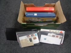 A box containing albums and folders, 20th century world stamps and First Day covers.