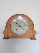 A 1930s oak cased Garrard mantel clock with silvered dial, pendulum and key.