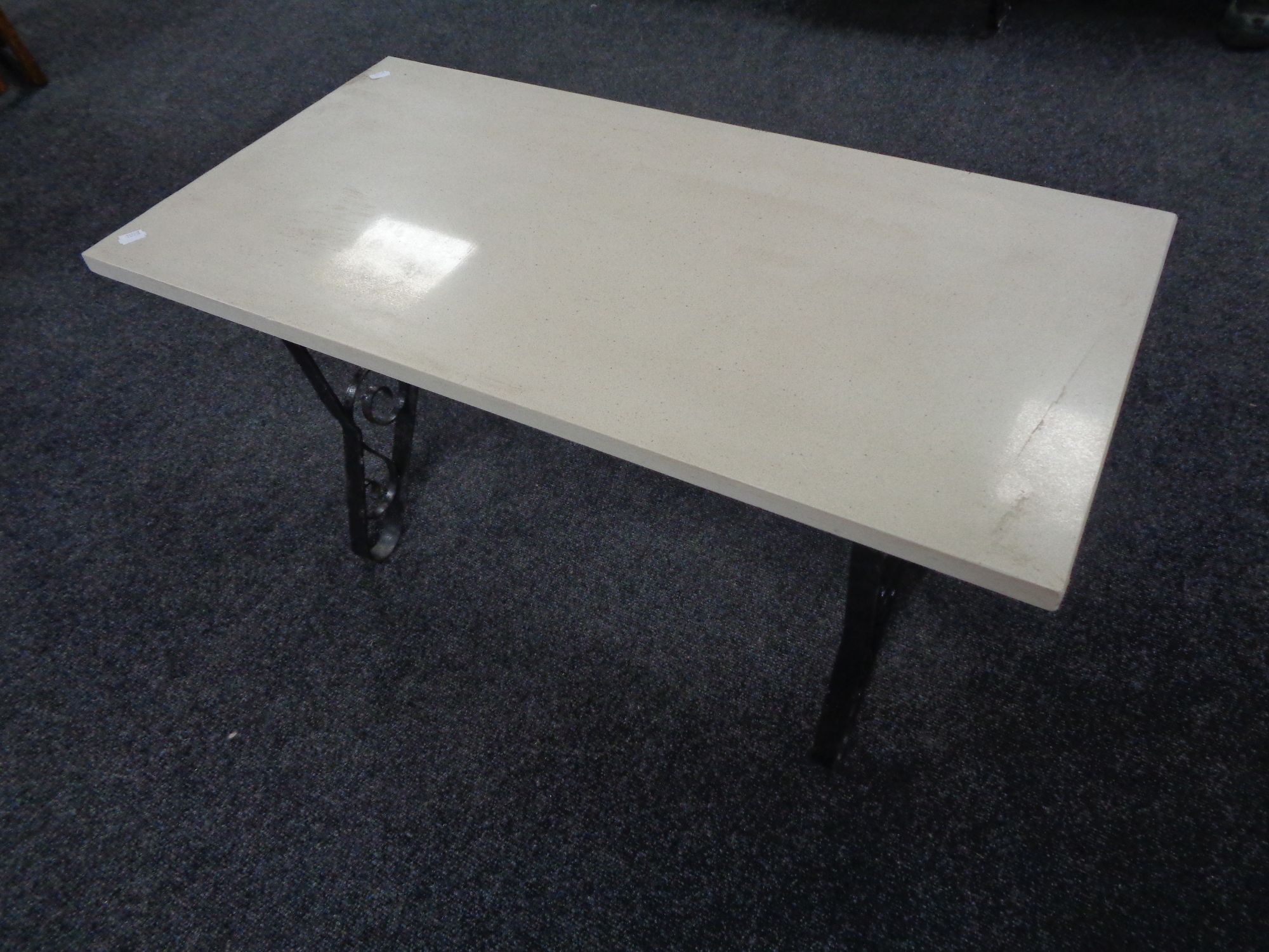 A marble topped coffee table on a wrought iron base.