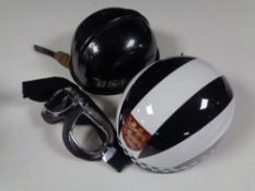 Two vintage motorcycle helmets, one marked BSA, together with a pair of motorcycle goggles.