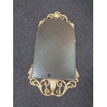 A cream and gilt framed arch topped bevel edged mirror.