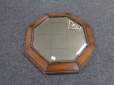 An Edwardian oak octagonal framed beaded bevel edged mirror.