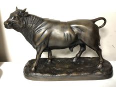 A patinated metal figure of a bull.