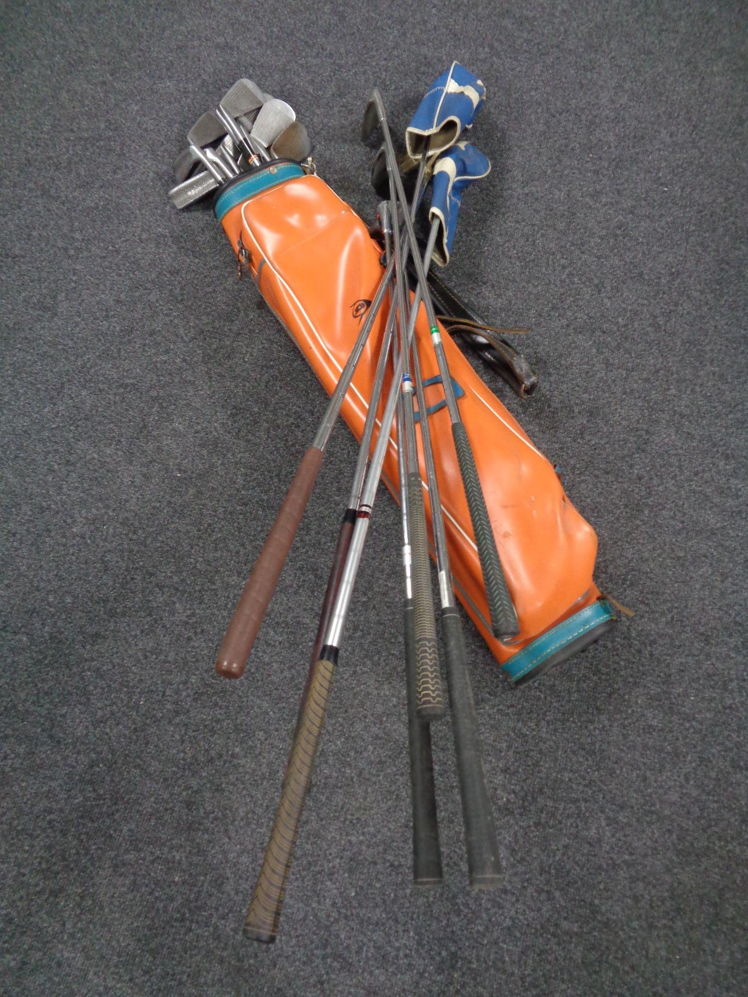 A vintage Dunlop golf bag containing assorted drivers, irons and putters.