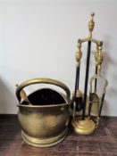 A brass coal bucket with shovel together with a four piece brass companion set on stand.