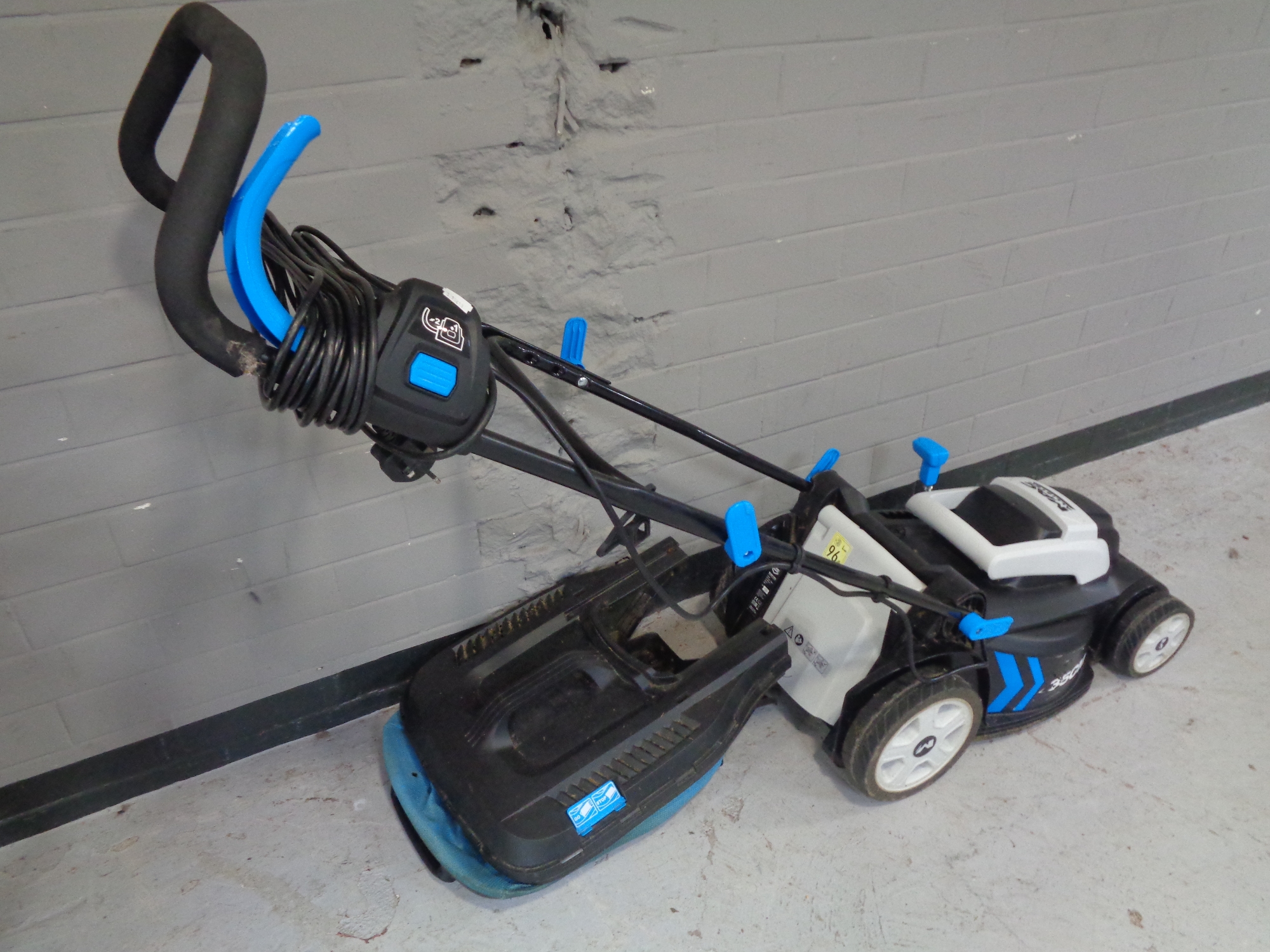 A Macallister electric lawn mower with grass box.