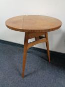 A circular Arts and Crafts oak cricket-style table