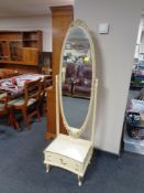 A cream and gilt cheval mirror, fitted a drawer.