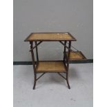 An early 20th century flap sided bamboo and wicker two tier occasional table