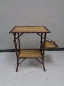 An early 20th century flap sided bamboo and wicker two tier occasional table