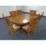 An American style circular extending dining table with leaf together with a set of six high backed