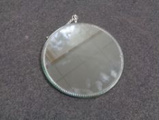 An early 20th century frameless circular etched mirror with metal back.