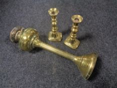 A Victorian brass oil lamp base, height 49 cm, together with a pair of candlesticks.