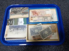 A group of antique bank notes and postcards, one ounce fine silver ingot.