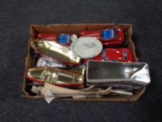 A box containing tins in the form of racing cars, enamel candle stick holder, paper ephemera.