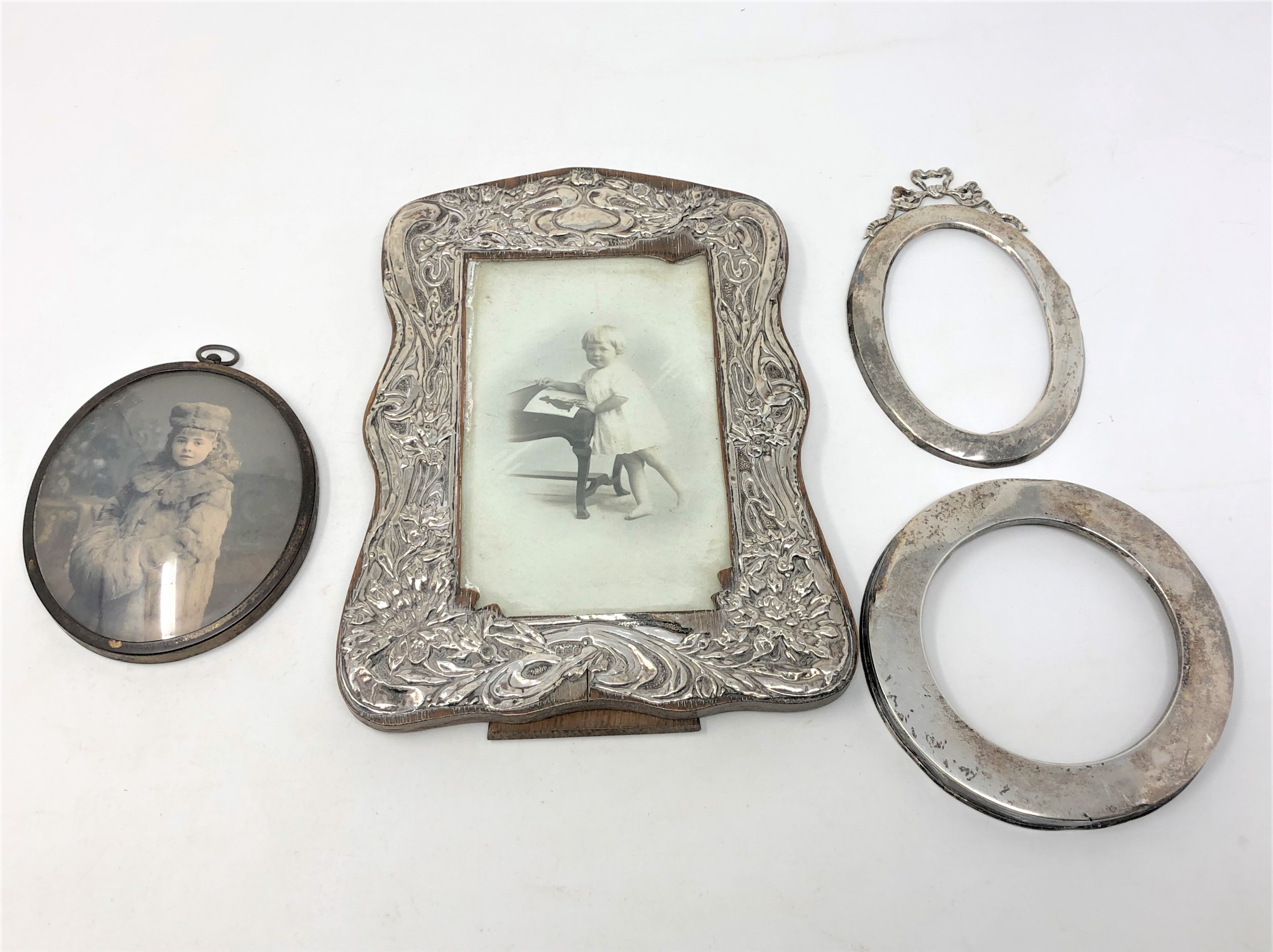 Three silver photograph frames, plus one other frame.