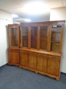 An inlaid yew wood four door bookcase, fitted cupboards and drawers beneath,