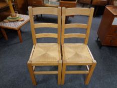 A pair of pine rush seated ladder back chairs.