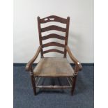 A 19th century oak ladder back armchair with rush seat.