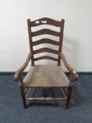 A 19th century oak ladder back armchair with rush seat.