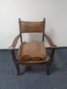 An oak framed Arts & Crafts armchair with a tooled leather back.