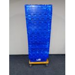 15 blue plastic storage crates together with two dollies.