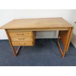 A mid 20th century teak flap sided single pedestal desk, fitted three drawers.