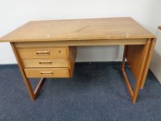 A mid 20th century teak flap sided single pedestal desk, fitted three drawers.