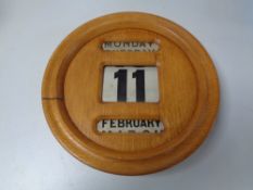 An Edwardian oak cased wall calendar.