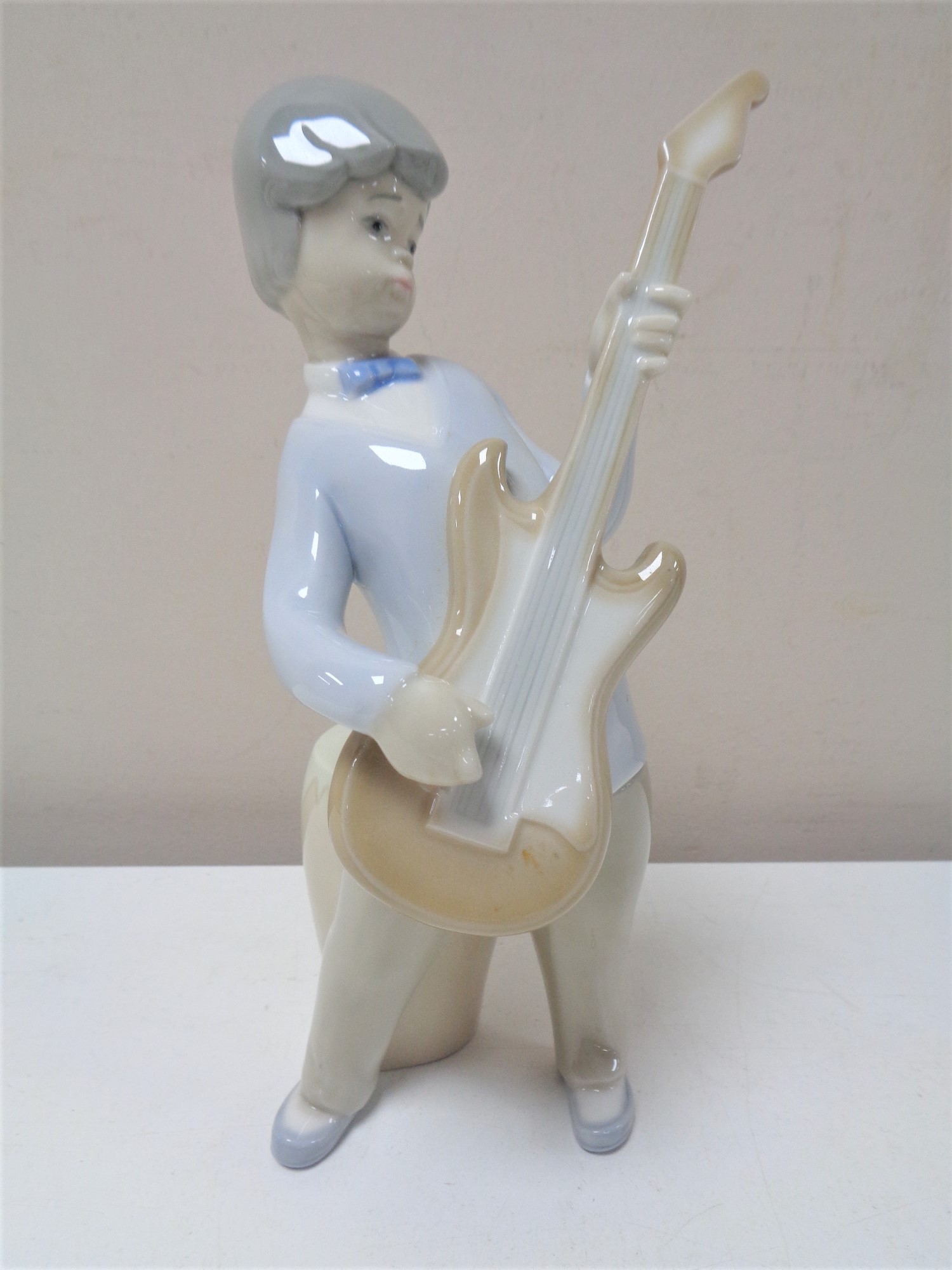 A Lladro figure of a boy with guitar