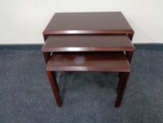 A nest of three mid 20th century rosewood tables.