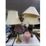 A pair of black and gold Grecian style table lamps with shades,