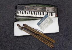 A Casio Casiotone MT-100 keyboard in carry bag together with a folding vintage music stand