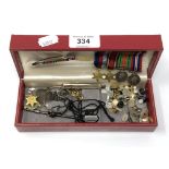 A box containing silver swizzle stick (a/f), miniature WWII medals, monocle,