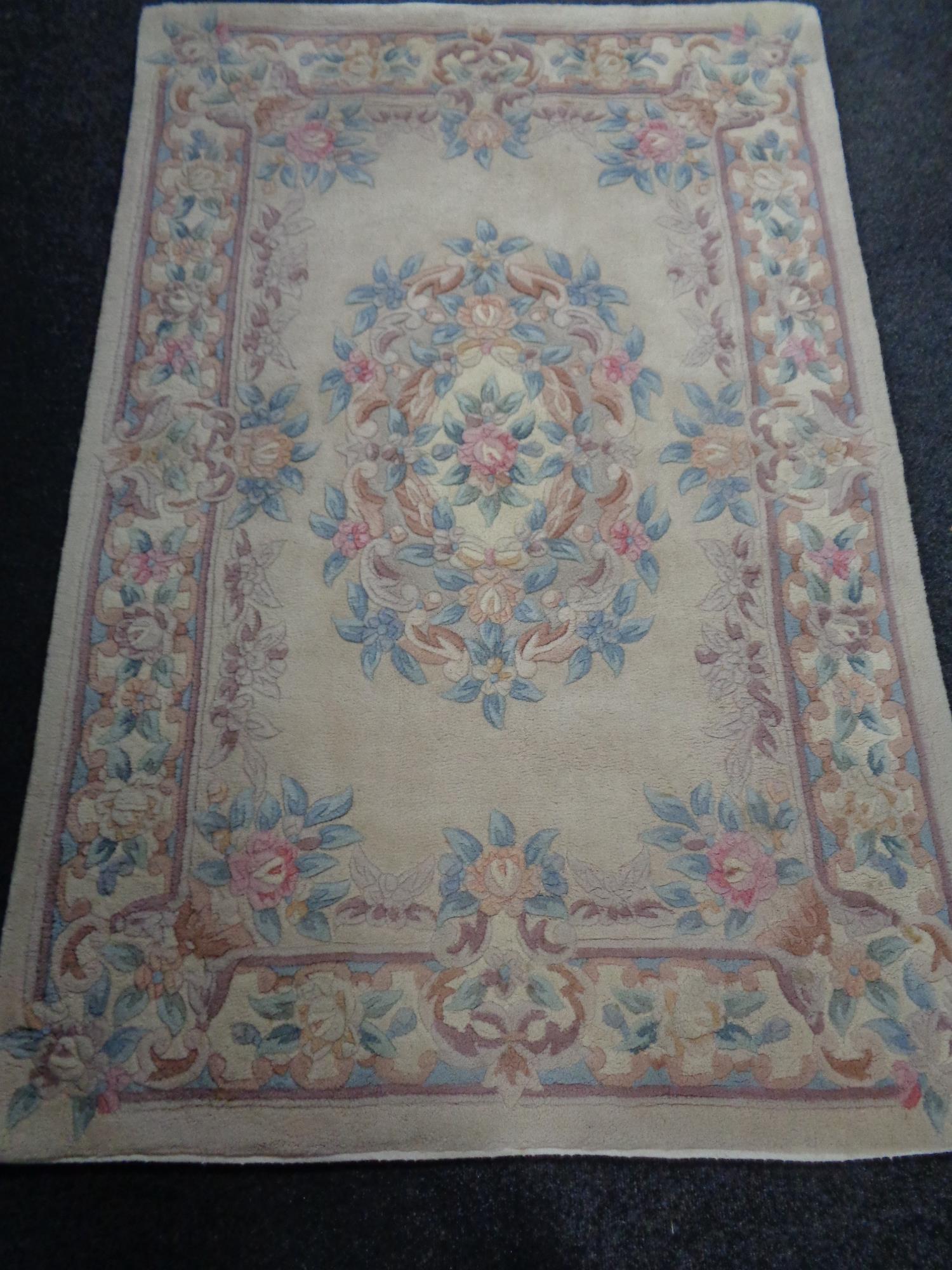 A floral Chinese rug on beige ground.
