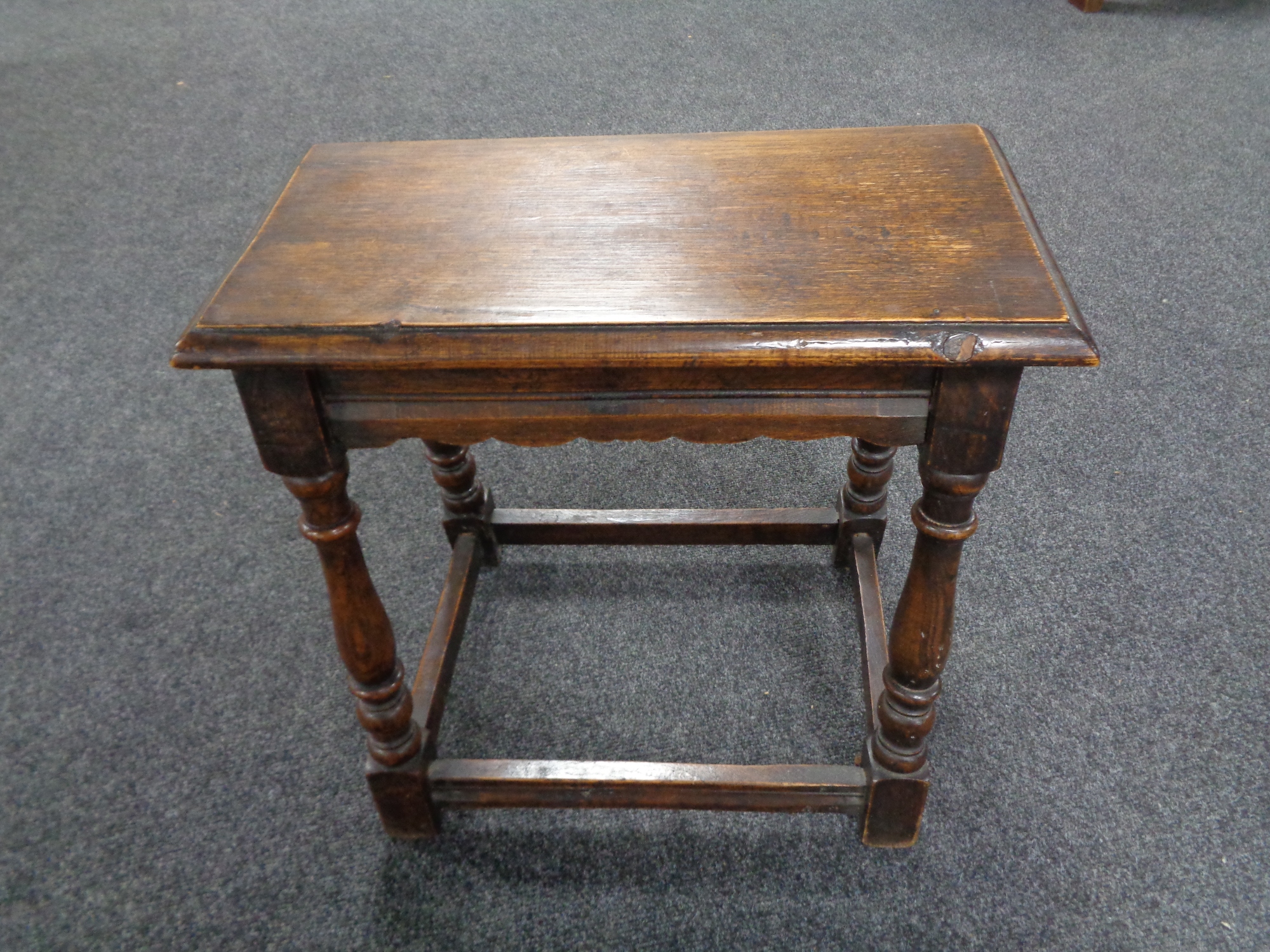 An antique oak jointed stool.