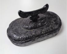 A cast iron boot scraper on painted stone base