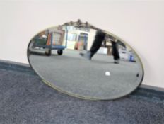 A twentieth century oval brass framed bevelled mirror