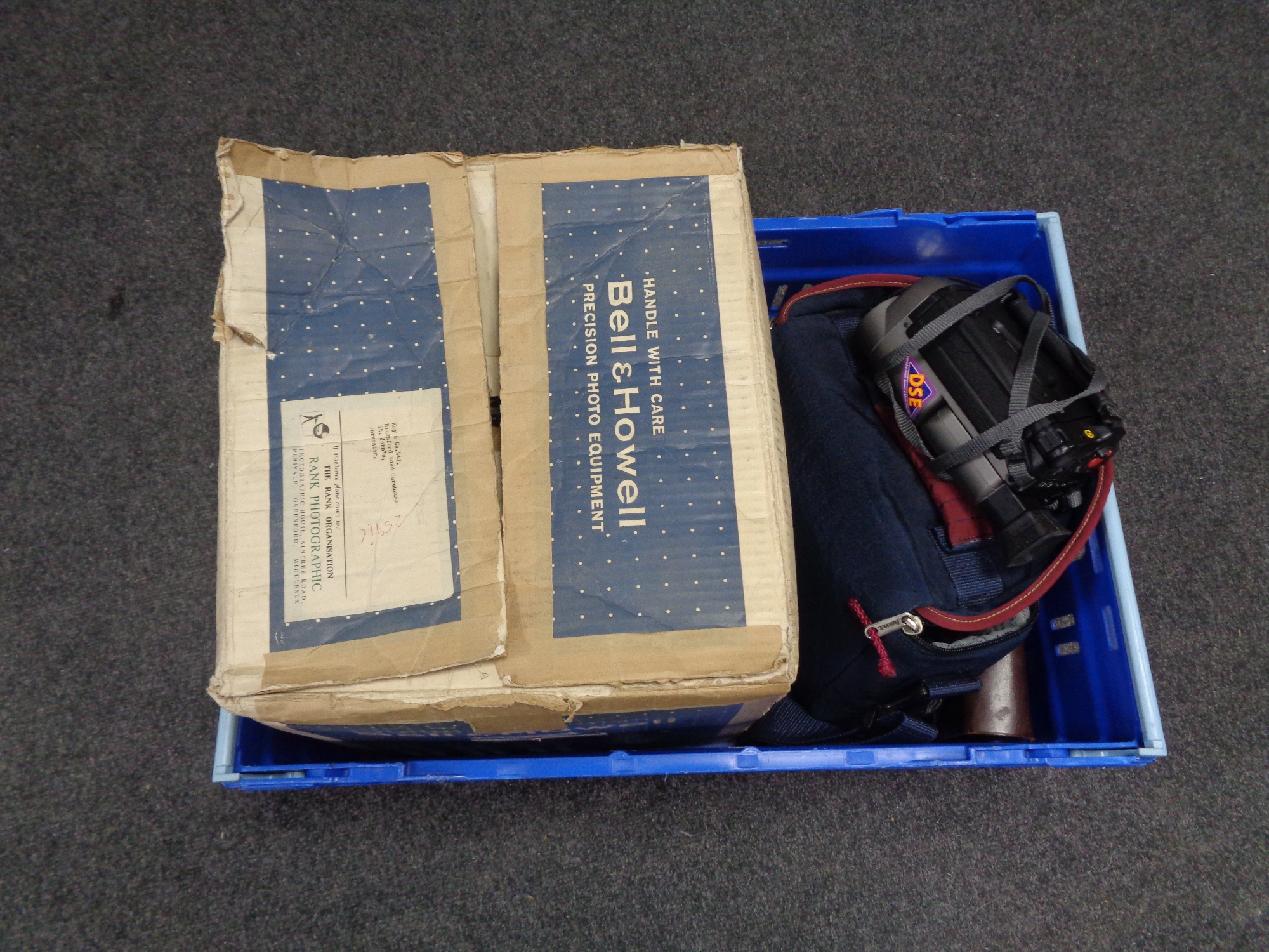 A crate containing a boxed Bell and Howell vintage projector together with a Samsung video camera,